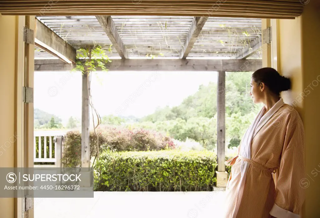 Woman in bathrobe looking out over Napa Valley, California at a luxury spa