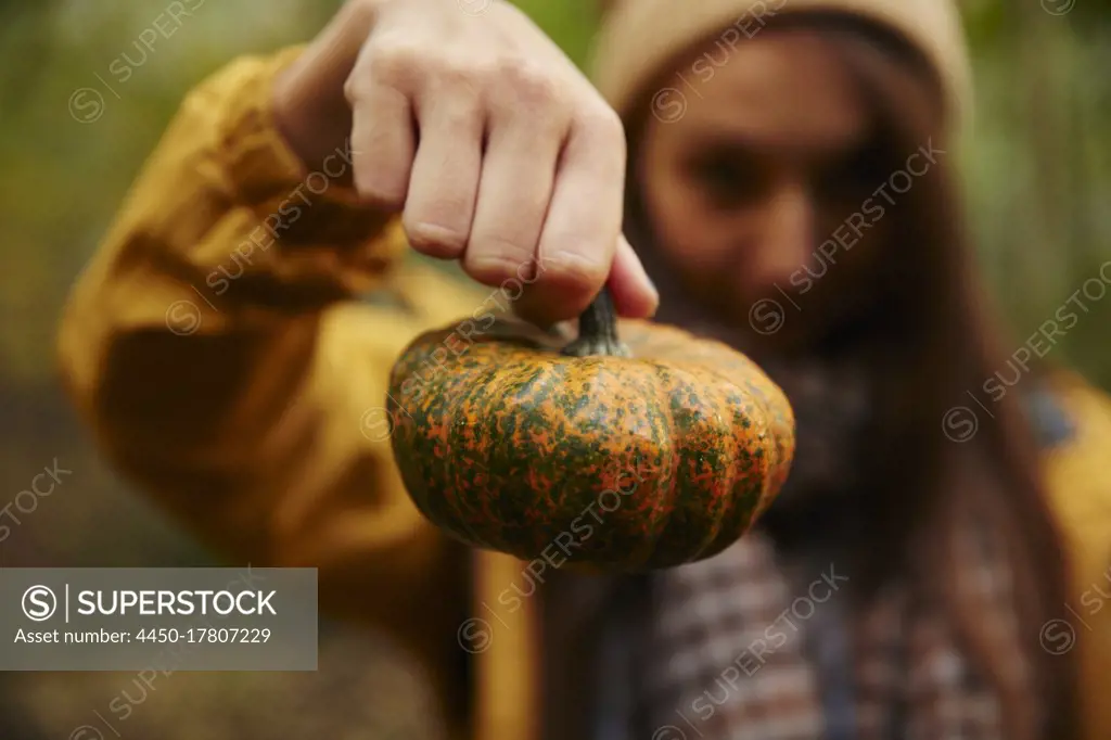 Woman holding up pumpkin to camera