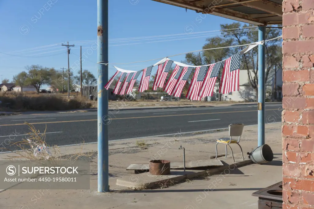 American flags in front of abandoned gas station.
