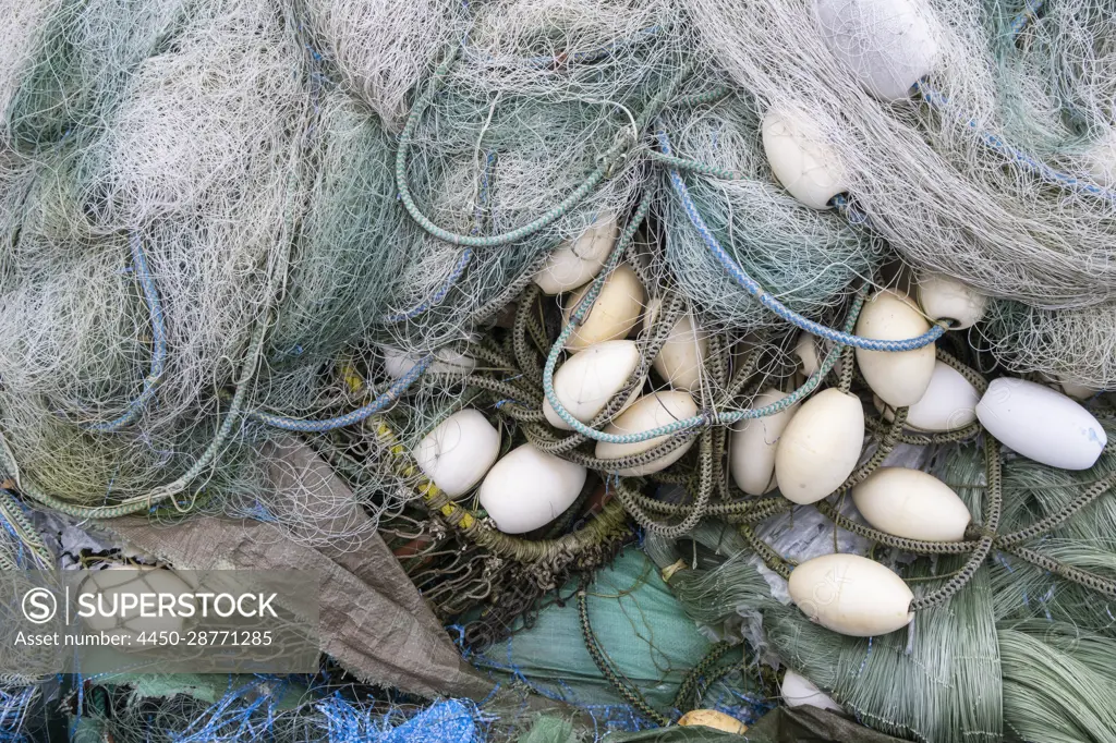 A pile of commercial fishing nets with plastic floats. - SuperStock