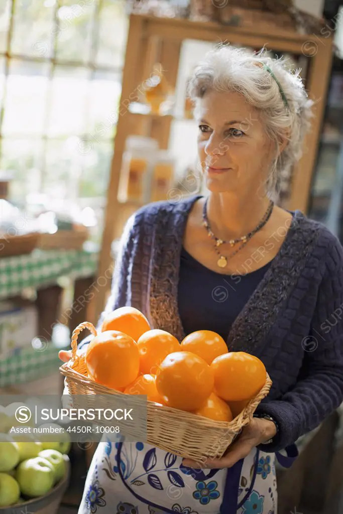 Organic Farmer at Work. A woman carrying a box of large oranges. Accord, New York, USA