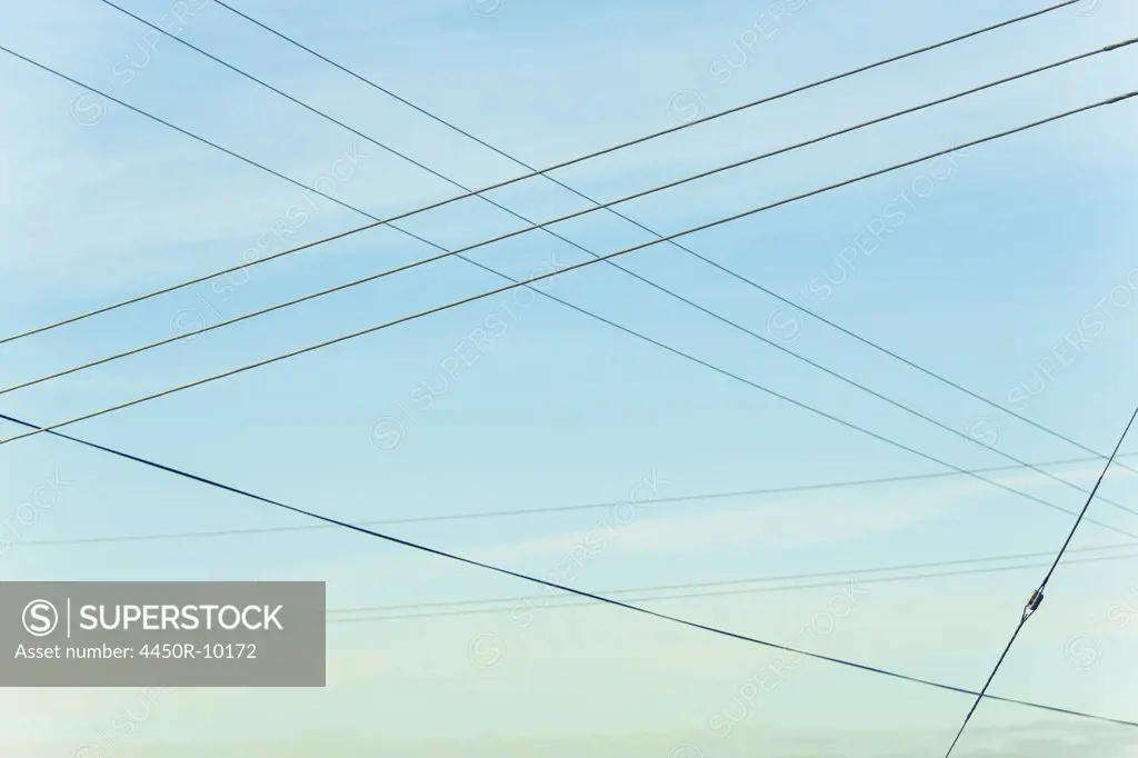 Power lines overhead, criss crossing in the air, at Belridge in California.Belridge, Kern County, California, USA
