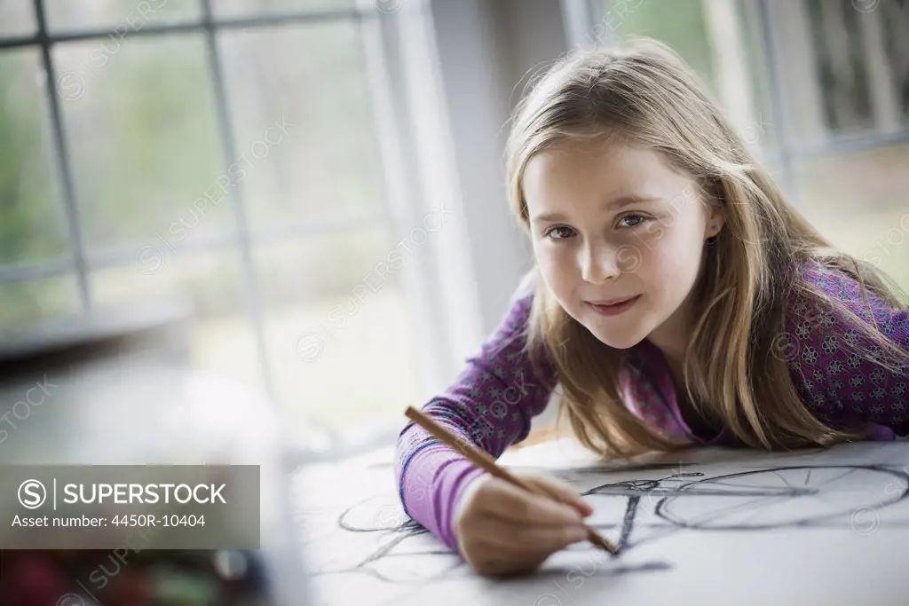 A family home.  A child sitting at a table using a pencil and creating a line drawing. Artwork. Drawing. Woodland Valley, New York, USA