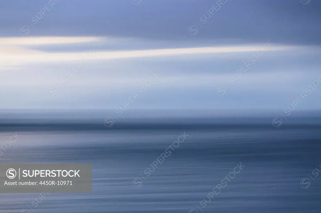 The sea and sky over Puget Sound in Washington, USA. The horizon with light cloud layers above.  Island County, Washington, USA