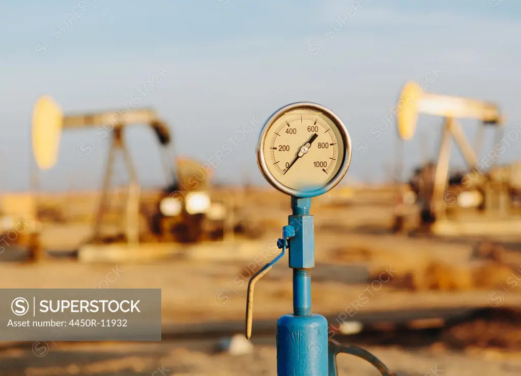 Air pressure gauge, oil rigs in background, Sunset-Midway oil fields, the largest in California. Taft, California, USA