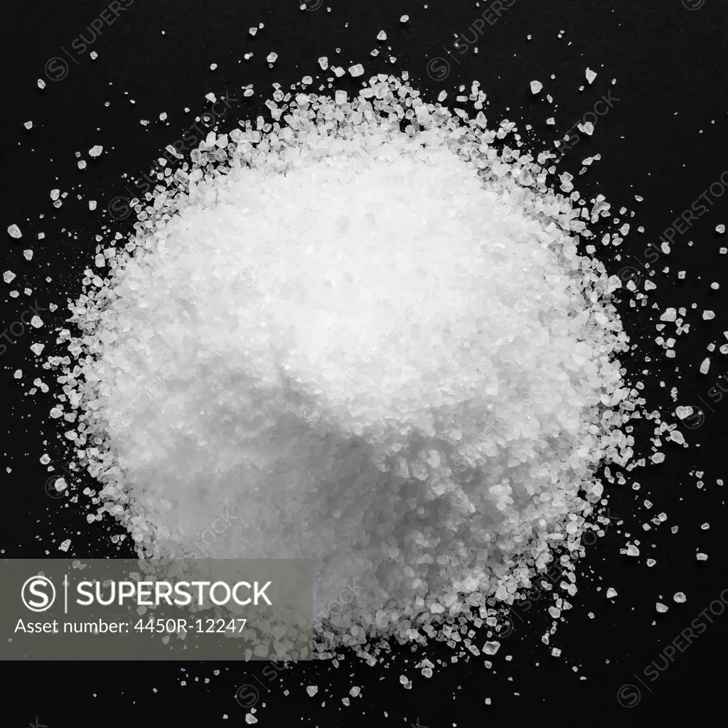 Pile of coarse sea salt grains on a black background. King County, Washington, USA