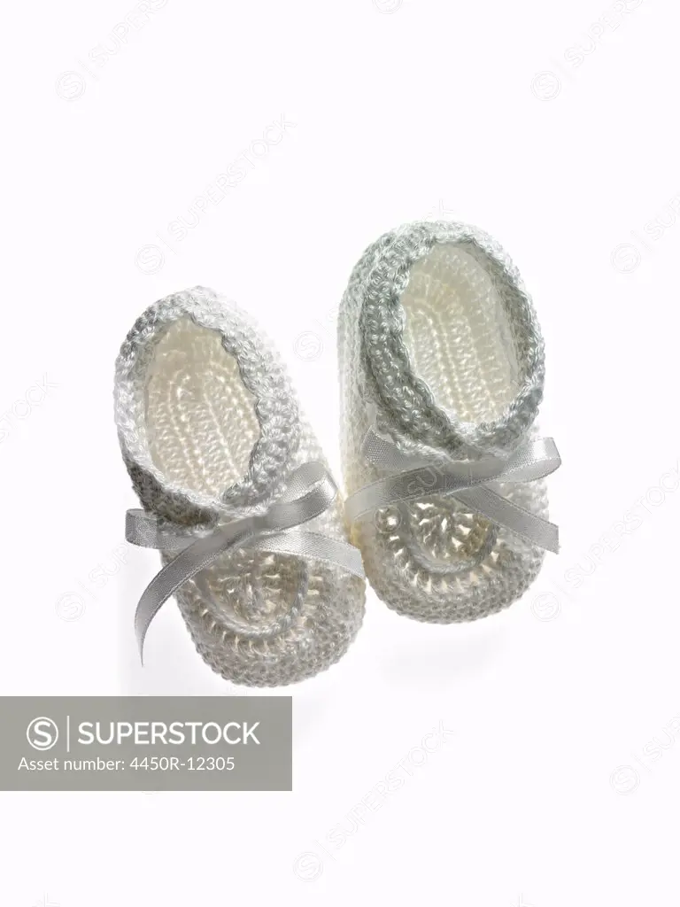 A pair of white baby booties, shoes for infants.  New York City, USA
