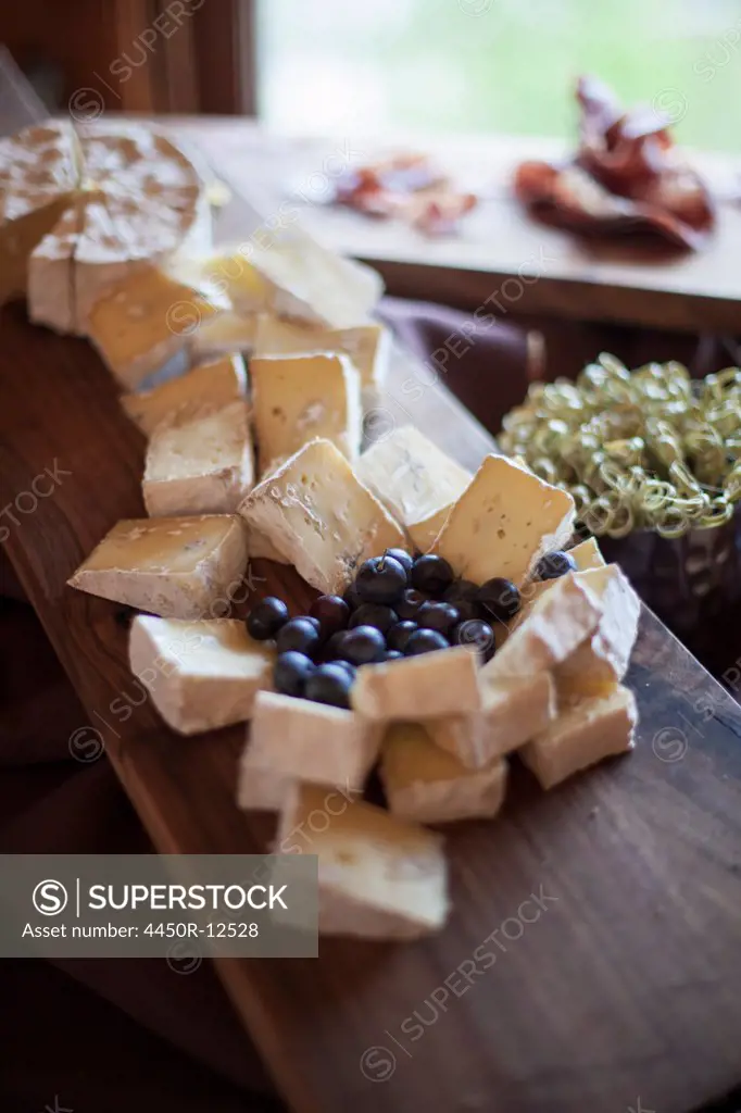 A wedding party meal.  A cheeseboard, with soft cheeses cut into triangles, and fresh fruits. Blueberries.  Park City, Utah, USA