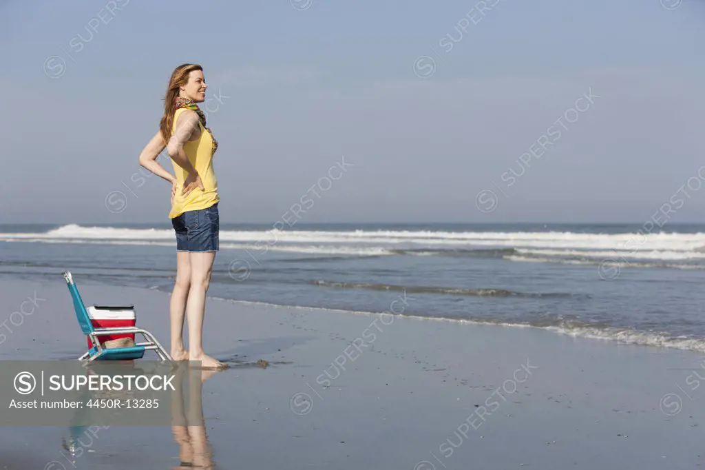 A woman in a sunhat and scarf on the beach on the New Jersey Shore, at Ocean City.  Ocean City, New Jersey, USA. 06/28/2012