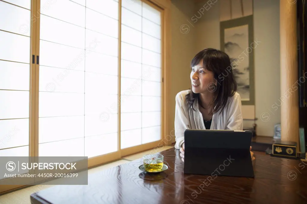 A woman sitting at a table with a laptop computer.