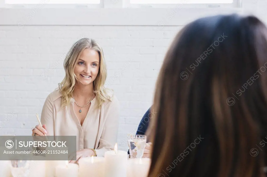 A woman sitting at a table with friends.