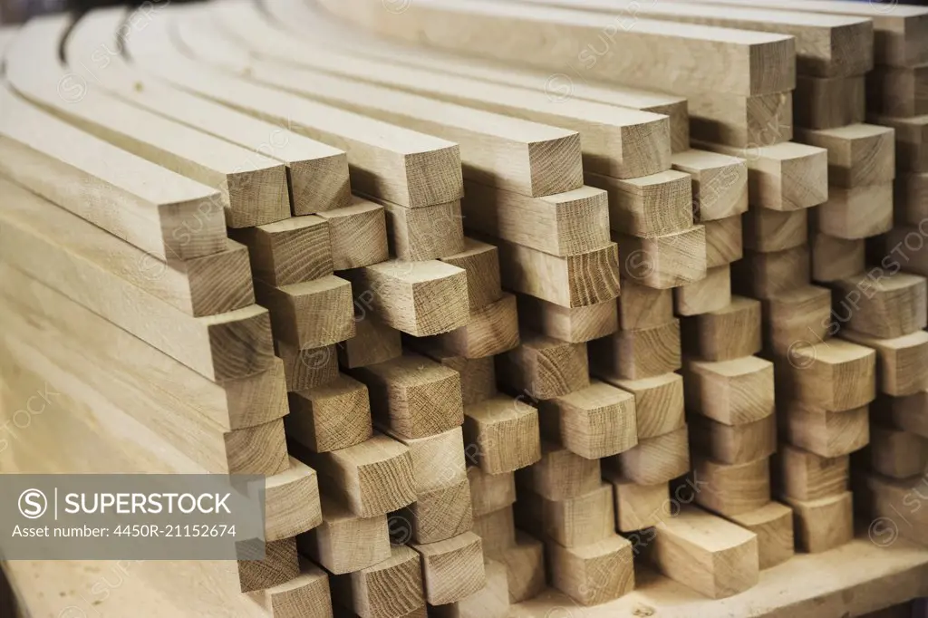 Close up of a stack of planed, curved square-edge timber pieces.