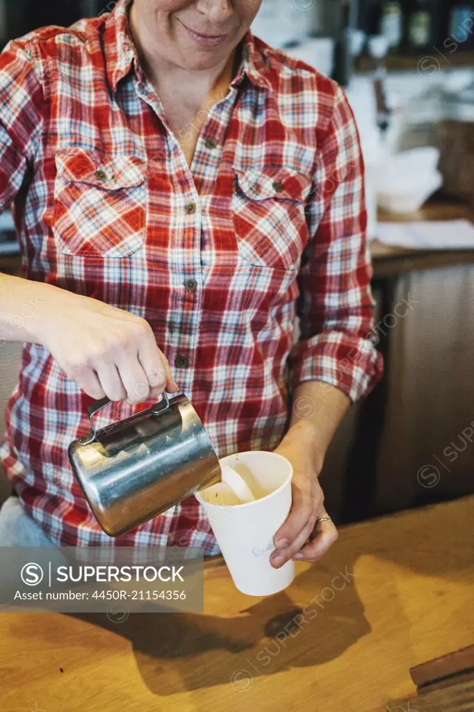 A woman working in a small commercial kitchen, a coffee shop owner.