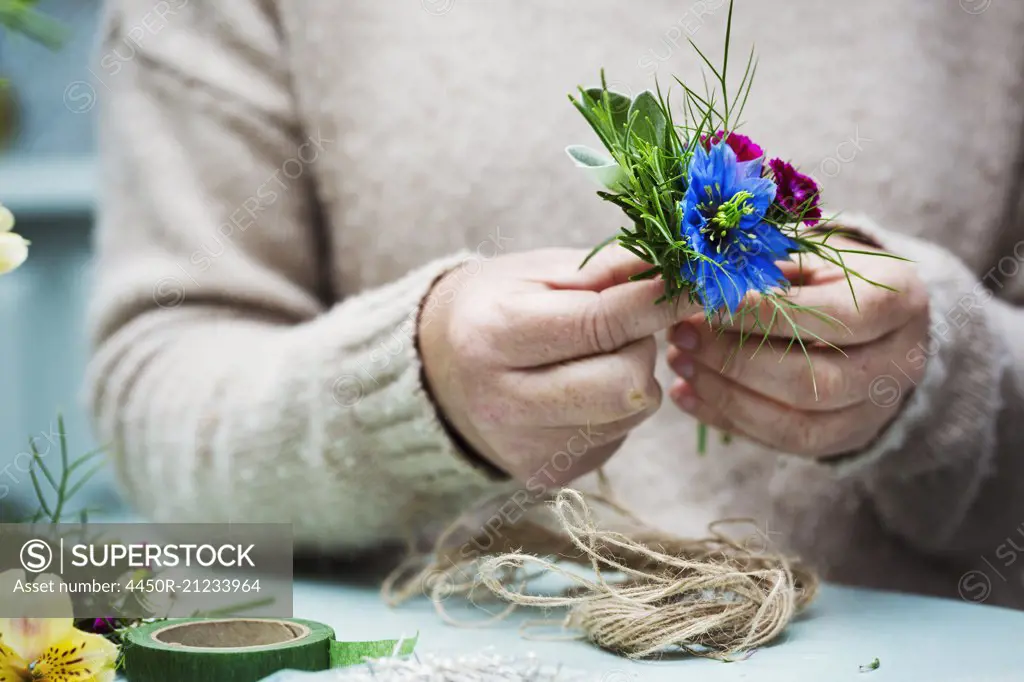 A florist working, creating a small posy.