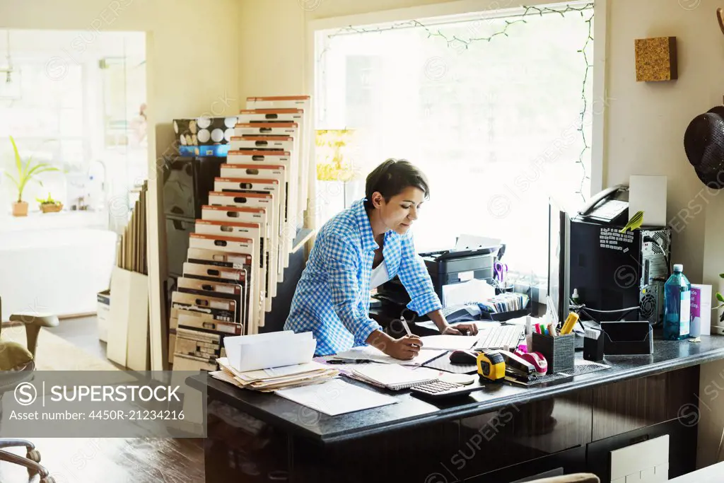 Woman working at a desk in an interior design studio and accessories store.