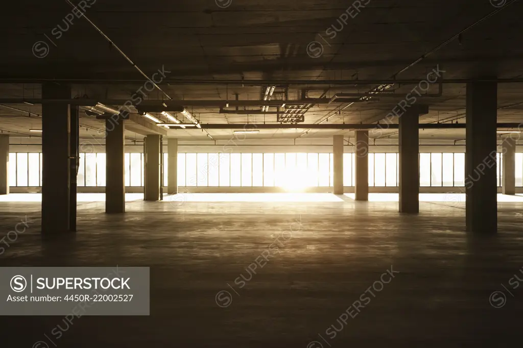 An empty raw business space ready for occupancy. Low light coming in the windows, lens flare.