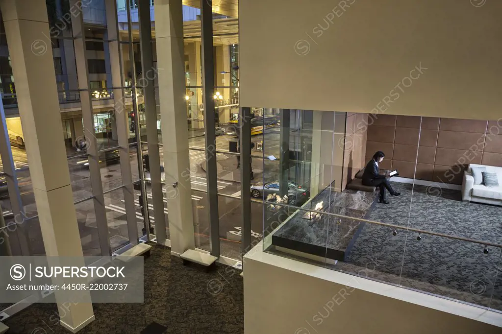 A view looking down into a conference room with a business woman looking at a notebook computer