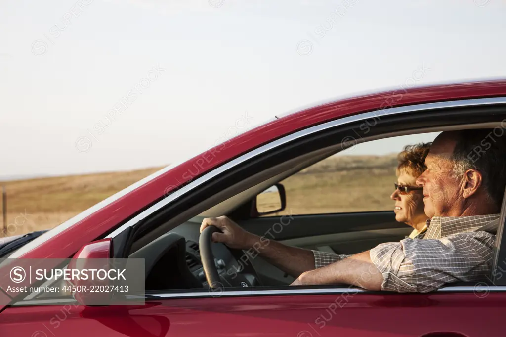 Caucasian senior couple in a car on a road trip.