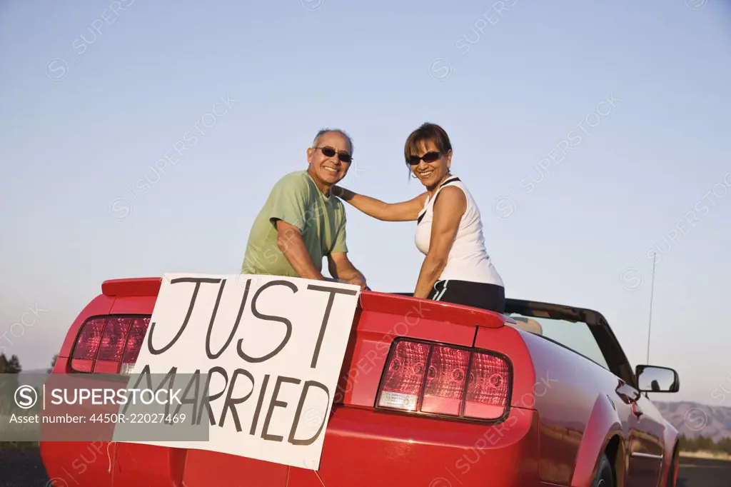 A senior couple "just married" sitting in a convertible sports car in eastern Washington State, USA.