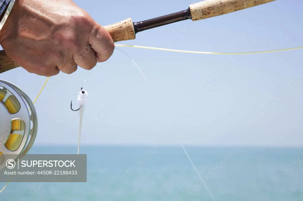 Hand of a fly fisherman preparing to cast for tarpon in Florida, USA
