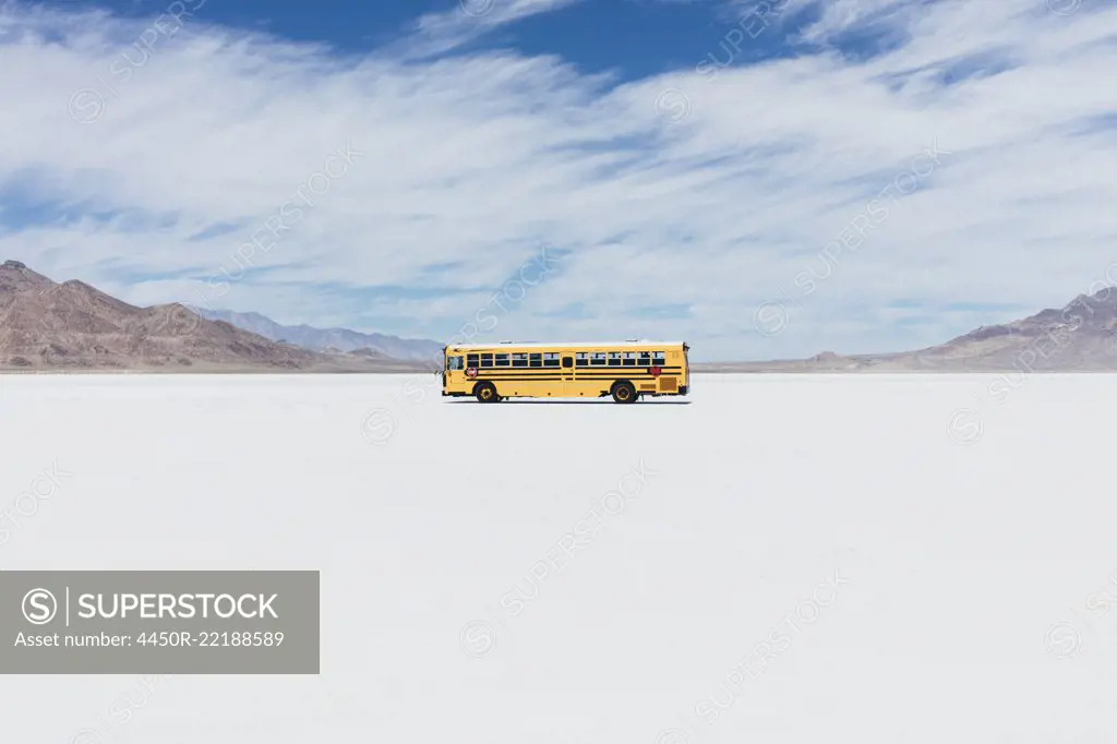 Yellow school bus driving on Salt Flats 