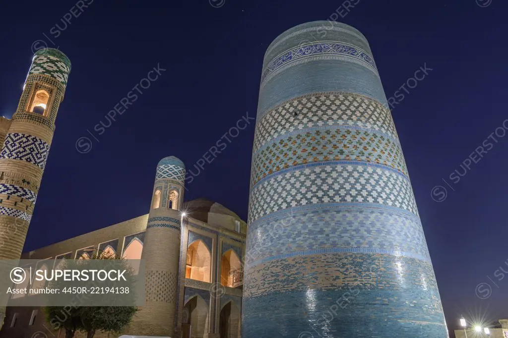 The historic mosque buildings with Kalta Minor minaret in the centre of the town of Khiva, Uzbekistan at night.