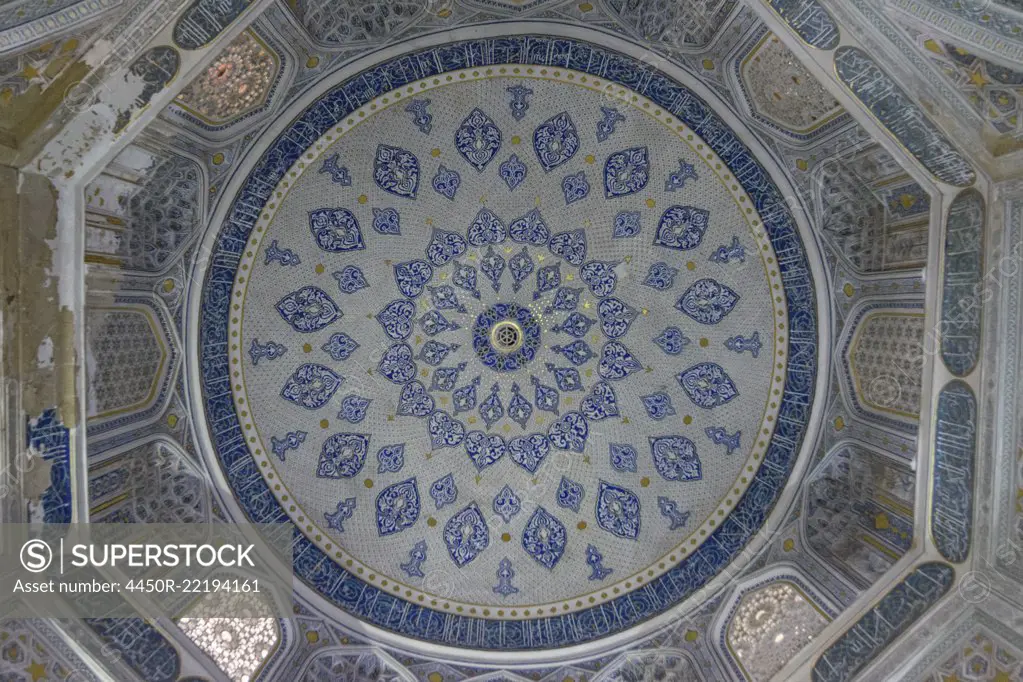 Interior, the blue and white patterned walls and dome of a Madrasa building in Samarkand.
