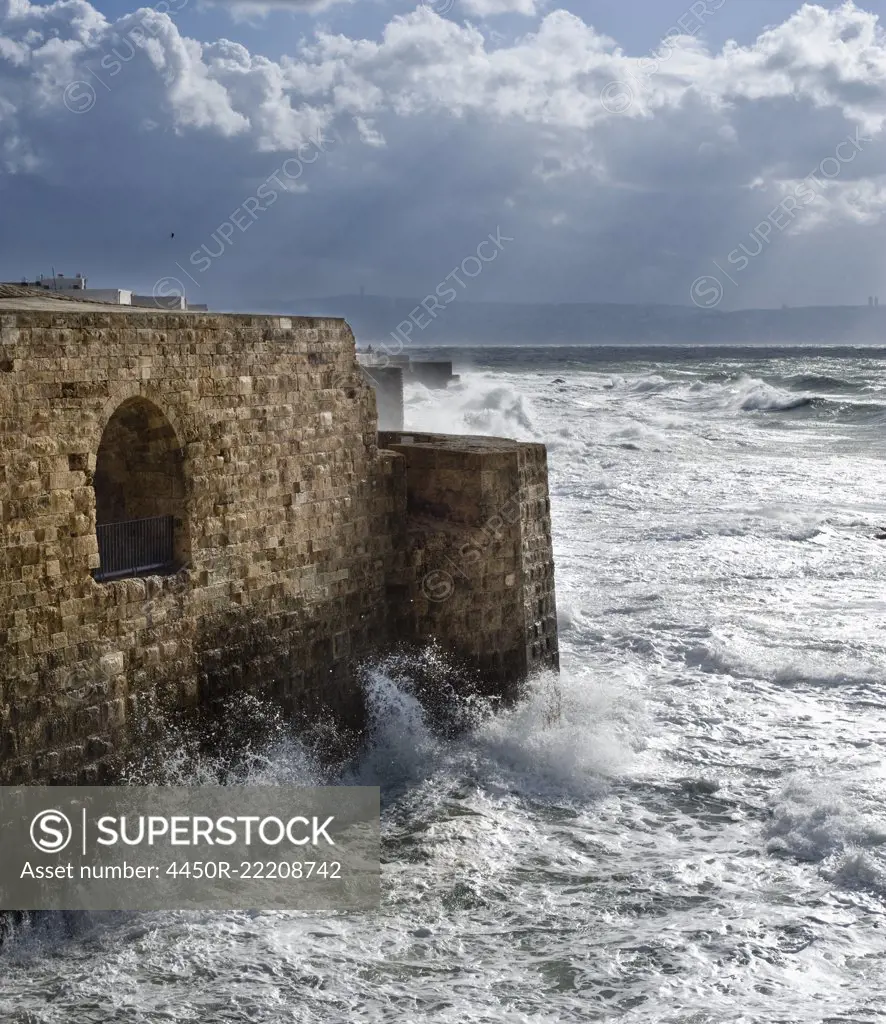Waves Breaking Against Ancient Walls During A Storm