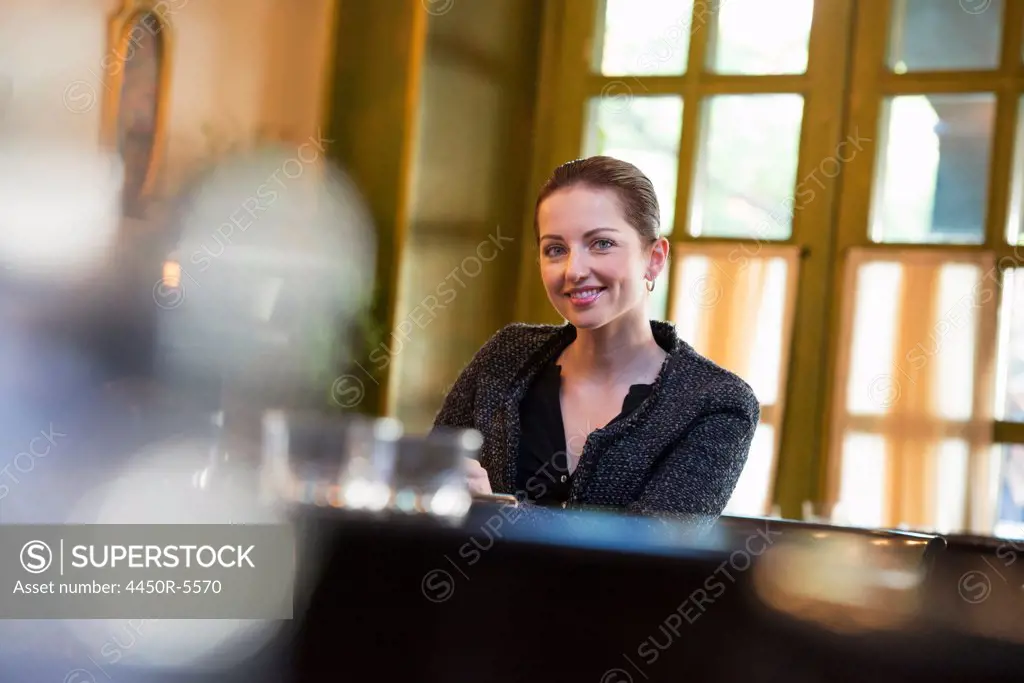 Business people outdoors. A woman sitting alone at a table in a coffee shop or restaurant.