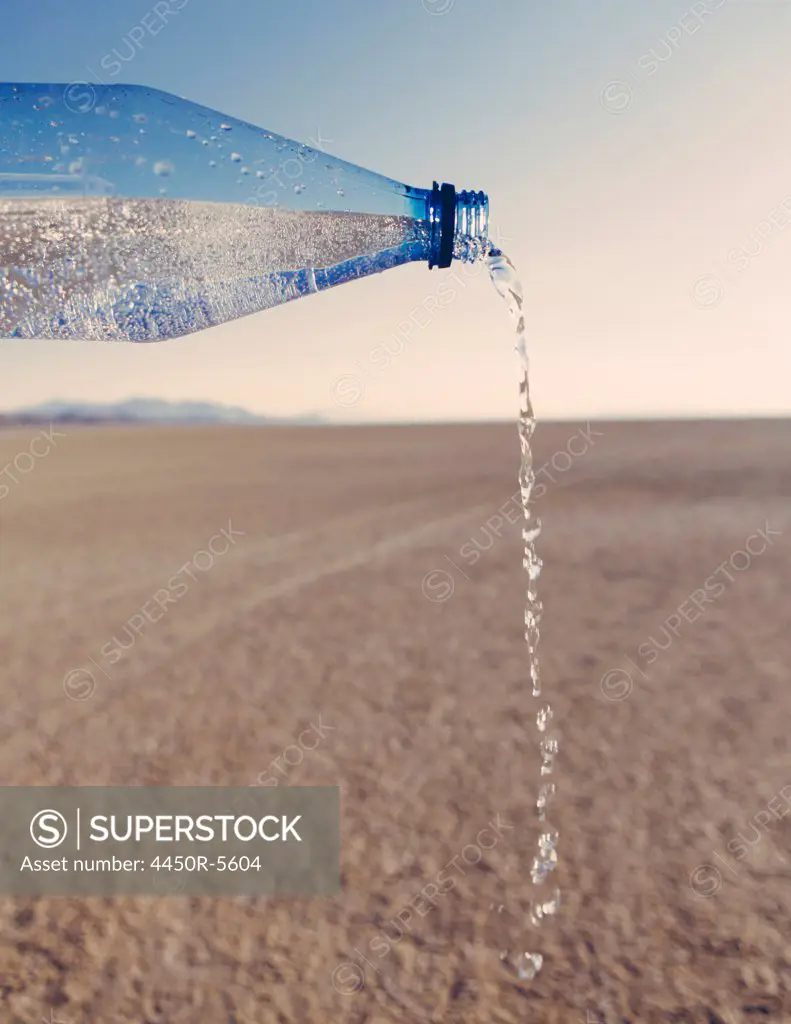 The landscape of the Black Rock Desert in Nevada. An essential element for survival. A bottle of water being poured out. Filtered mineral water.