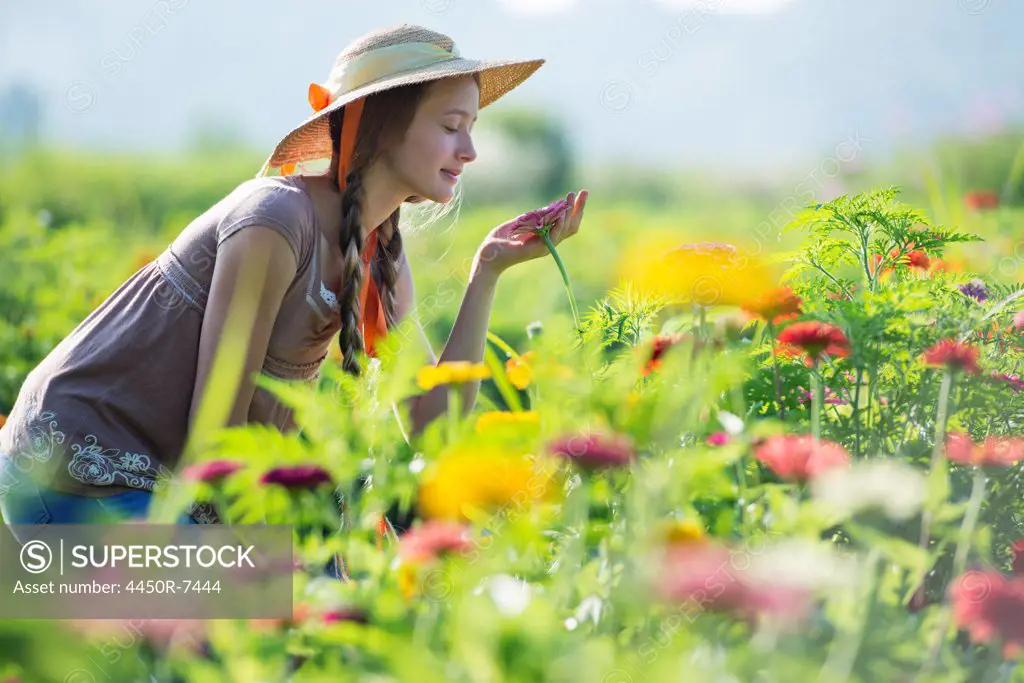 Summer on an organic farm. A young woman in a field of flowers.