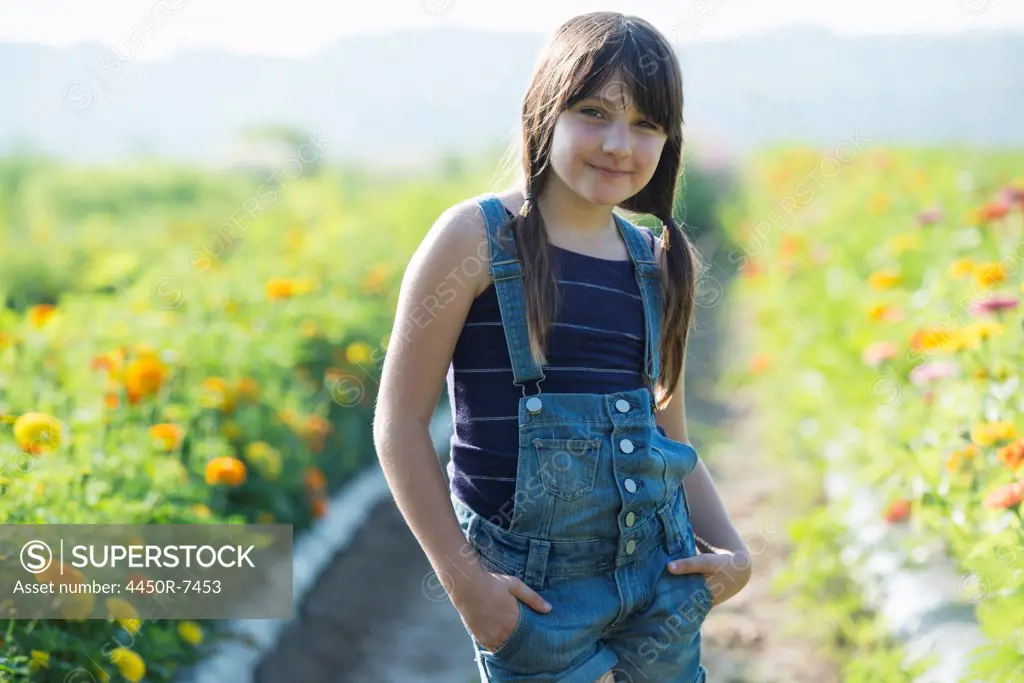 Summer on an organic farm. A young girl in a field of flowers.
