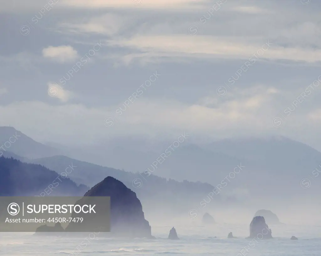 View of  Haystack Rock, at Cannon Beach and the coast of the Ecola State Park, Oregon.