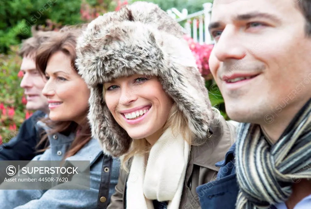 Four people outdoors in coats and scarves.