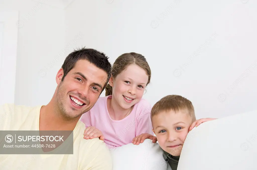 A man and two children at home, a boy and a girl.