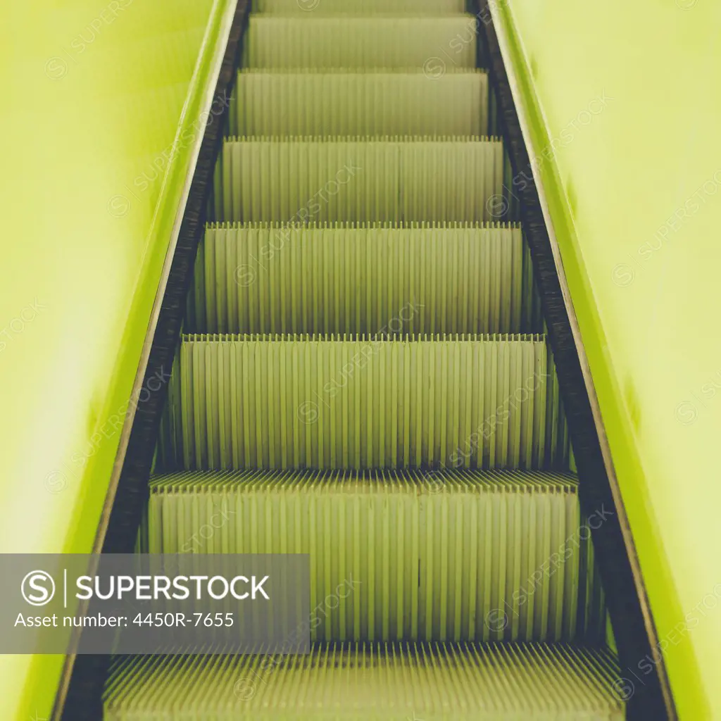 A flight of steps, an escalator with a yellow painted border stripe on each side.
