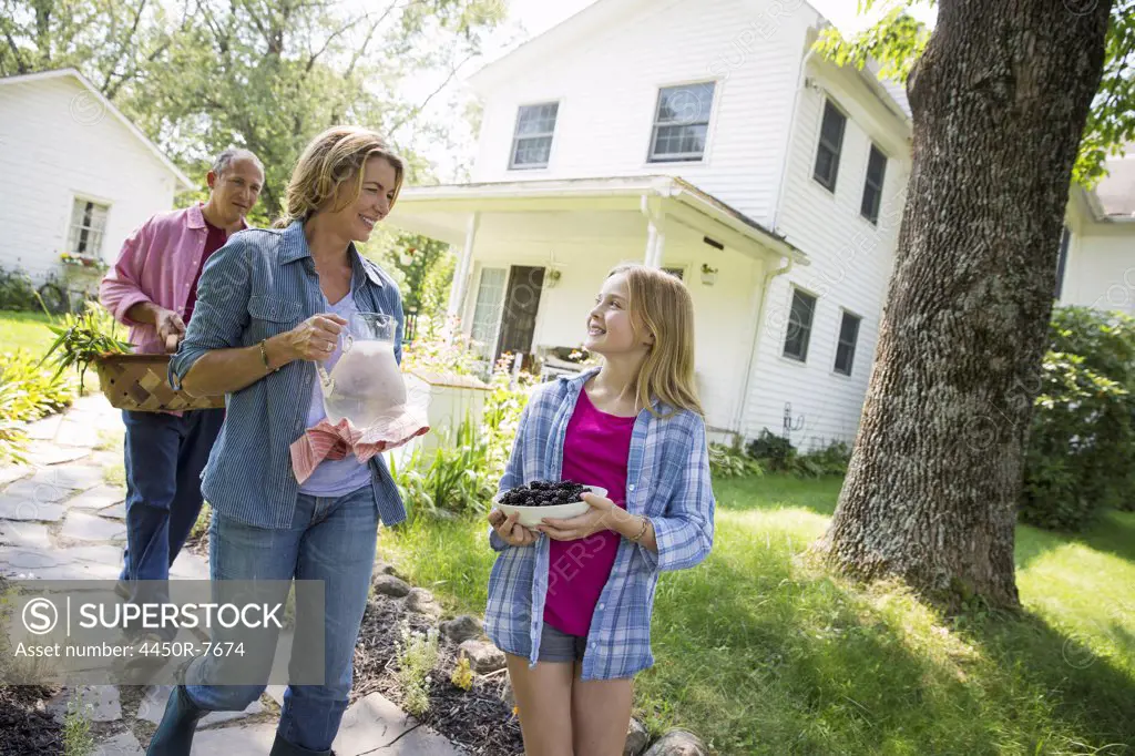 A family summer gathering at a farm. Two adults and a young girl.