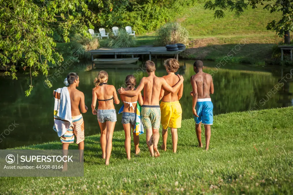 A large group of boys and girls, teenagers, running across a field. Maryland, USA. 7/1/2012