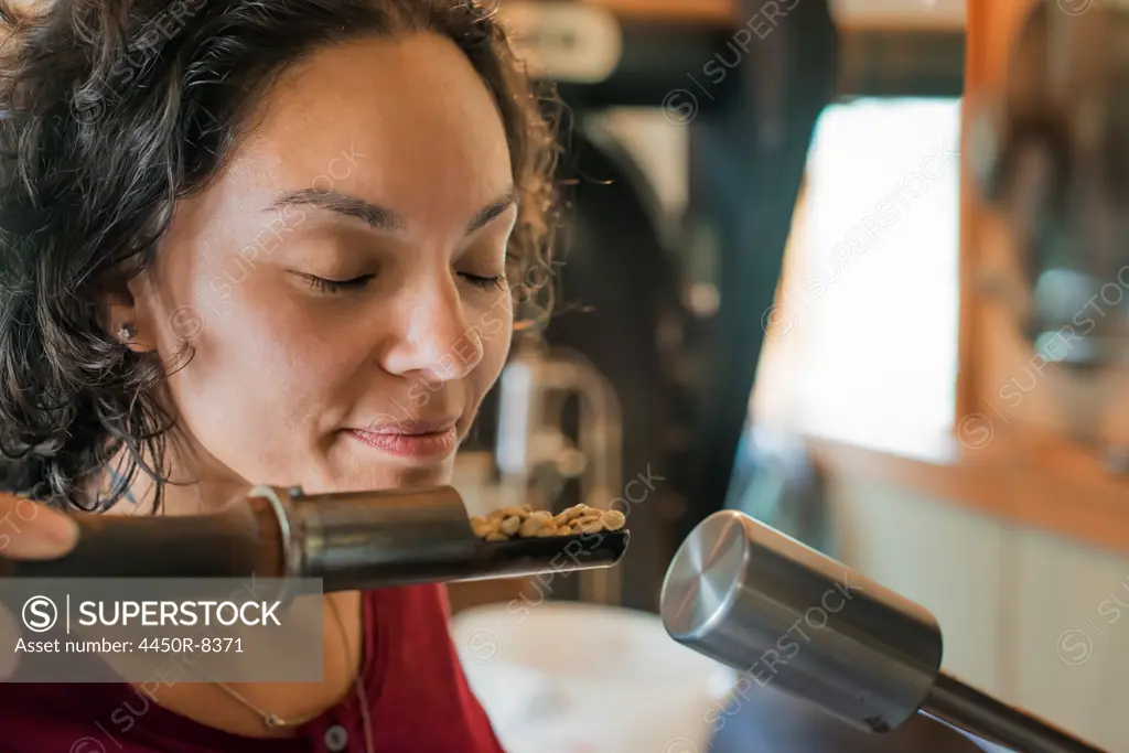 A person testing and smelling the aroma of the coffee at a bean processing shed, and testing and tasting area. New York state, USA. 3/25/2012