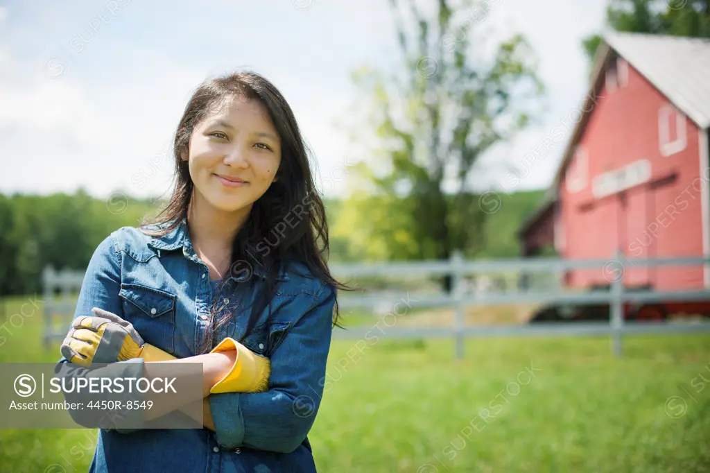 A young woman on a traditional farm in the countryside of New York State, USA. Woodstock, New York, USA. 7/4/2012