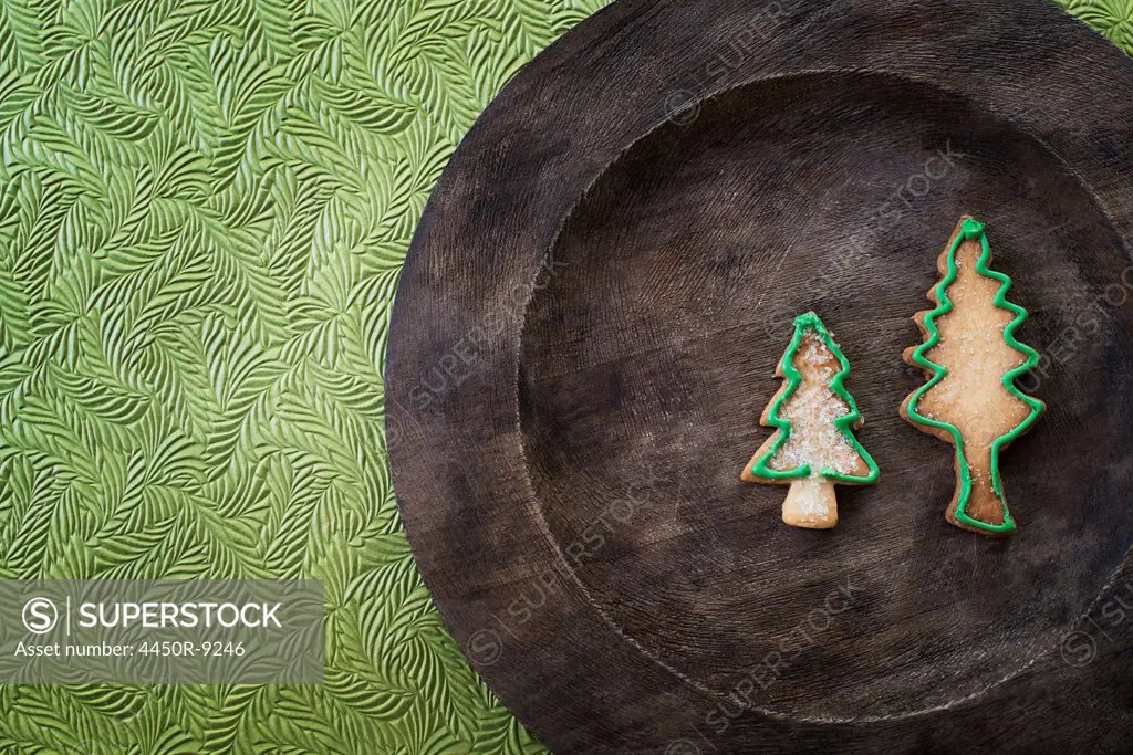 Organic homemade Christmas cookies in the shape of Christmas trees on a round wooden plate. Woodstock, New York, USA. 9/9/2012