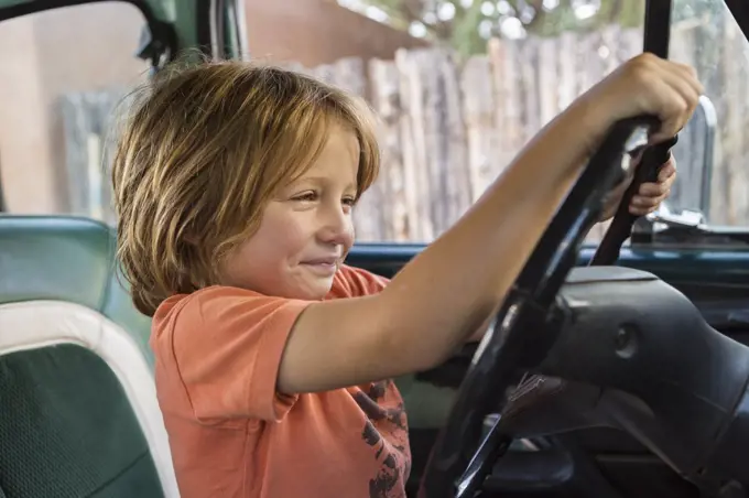 5 year old boy behind the wheel of 1970's pick up truckNM.