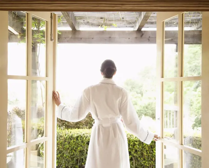 Woman in bathrobe walking out of a luxury spa overlooking wine country in California