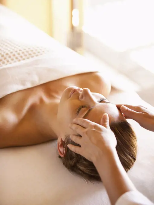 Woman lying on massage table receiving facial massage at a luxury spa in Napa Valley California