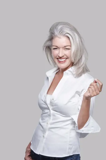 Portrait, attractive vivacious mature Caucasian woman with silver hair, laughing. 