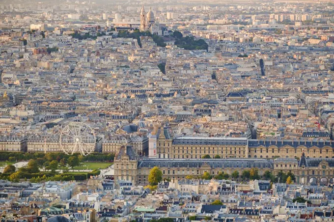 Aerial view of Paris, including the Louvre museum and Montmartre Cathedral.
