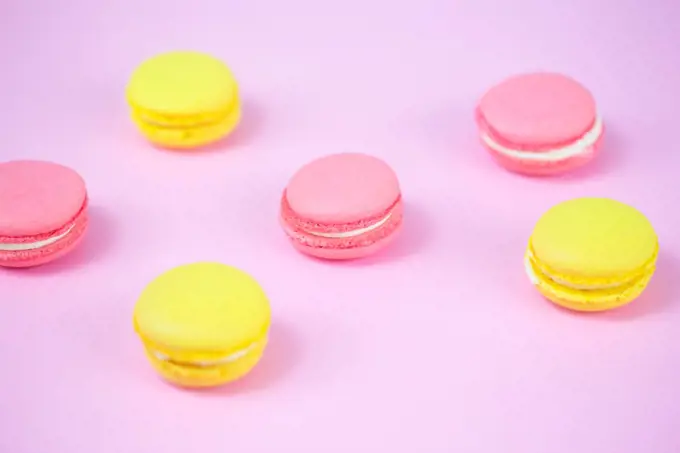 Pink and yellow macaroons, tasty sweet biscuits on a table. 