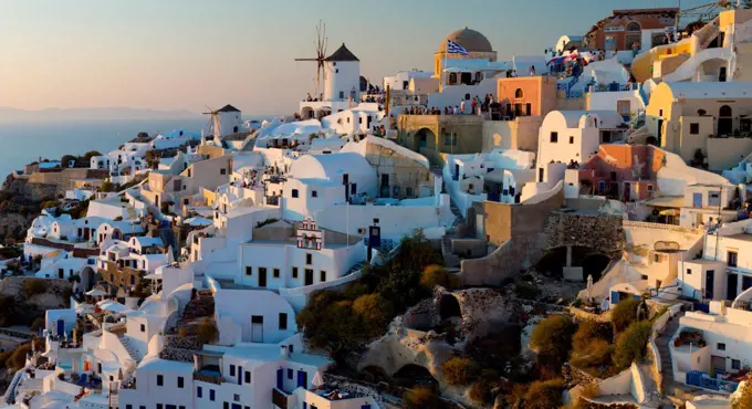 The windmills of Santorini in Greece. A hilltop town of whitewashed houses. Sunset.  Aegean Sea, Greece