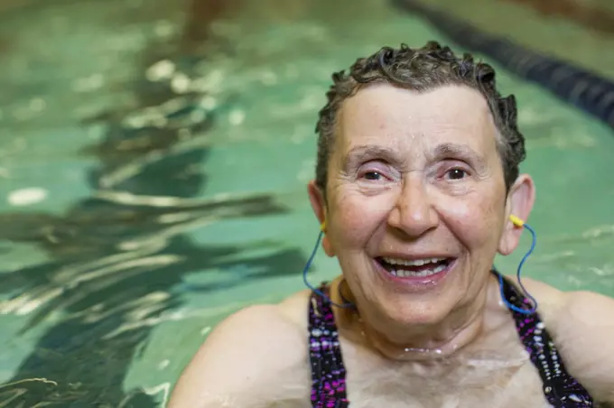 An elderly woman in a swimming pool, taking exercise.  Pennsylvania, USA. 12/08/2013