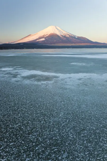 Ice on Lake Yamanaka with snow covered Mount Fuji in background, Japan.